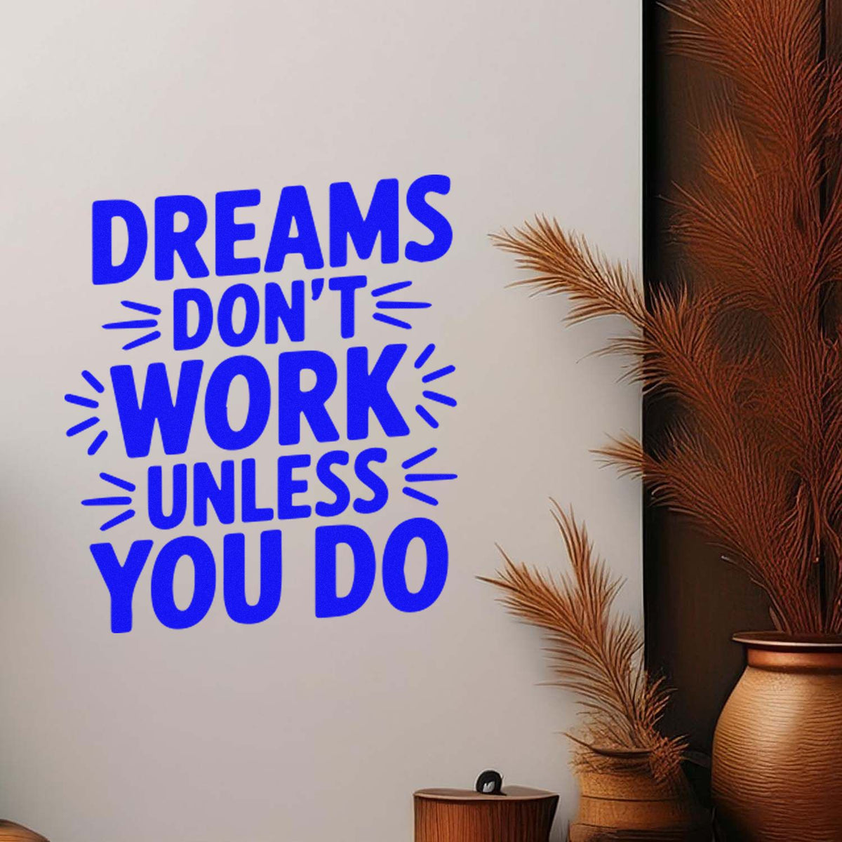 Blue custom stamp seal reading Dreams dont work unless you do on cream background, beside brown dried grass decor.