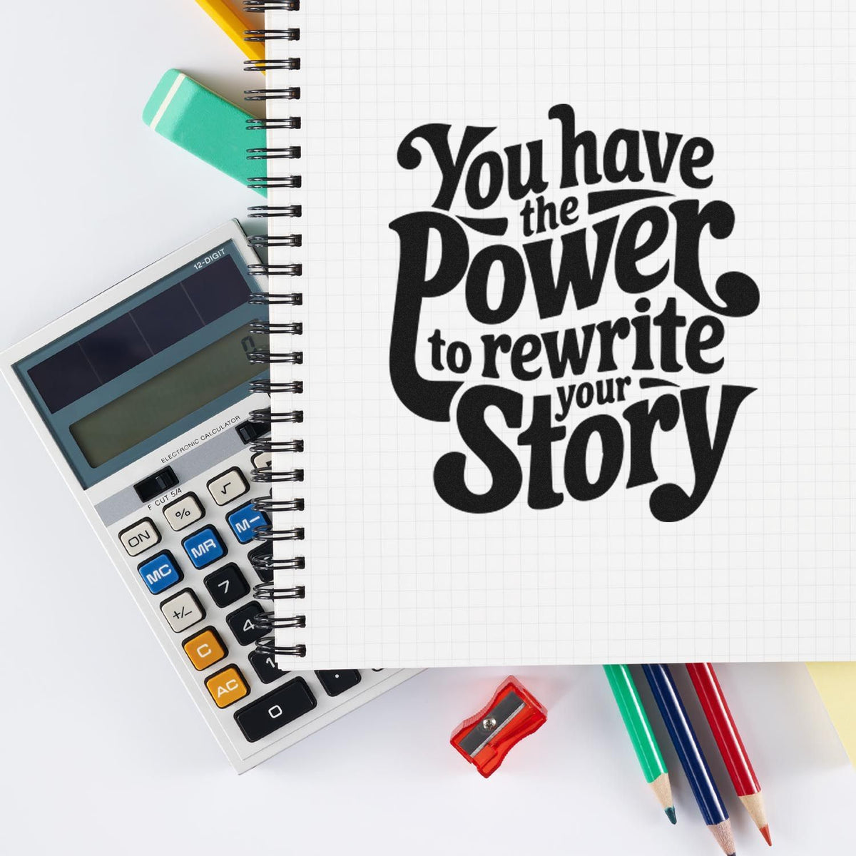 Bold black stamp and seal product reading You have the power to rewrite your story on a notebook, with calculator and colorful pencils.