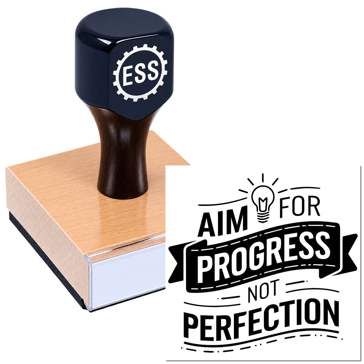 Dark blue ESS rubber seal stamp on a wood block with black "Aim for progress, not perfection" design.