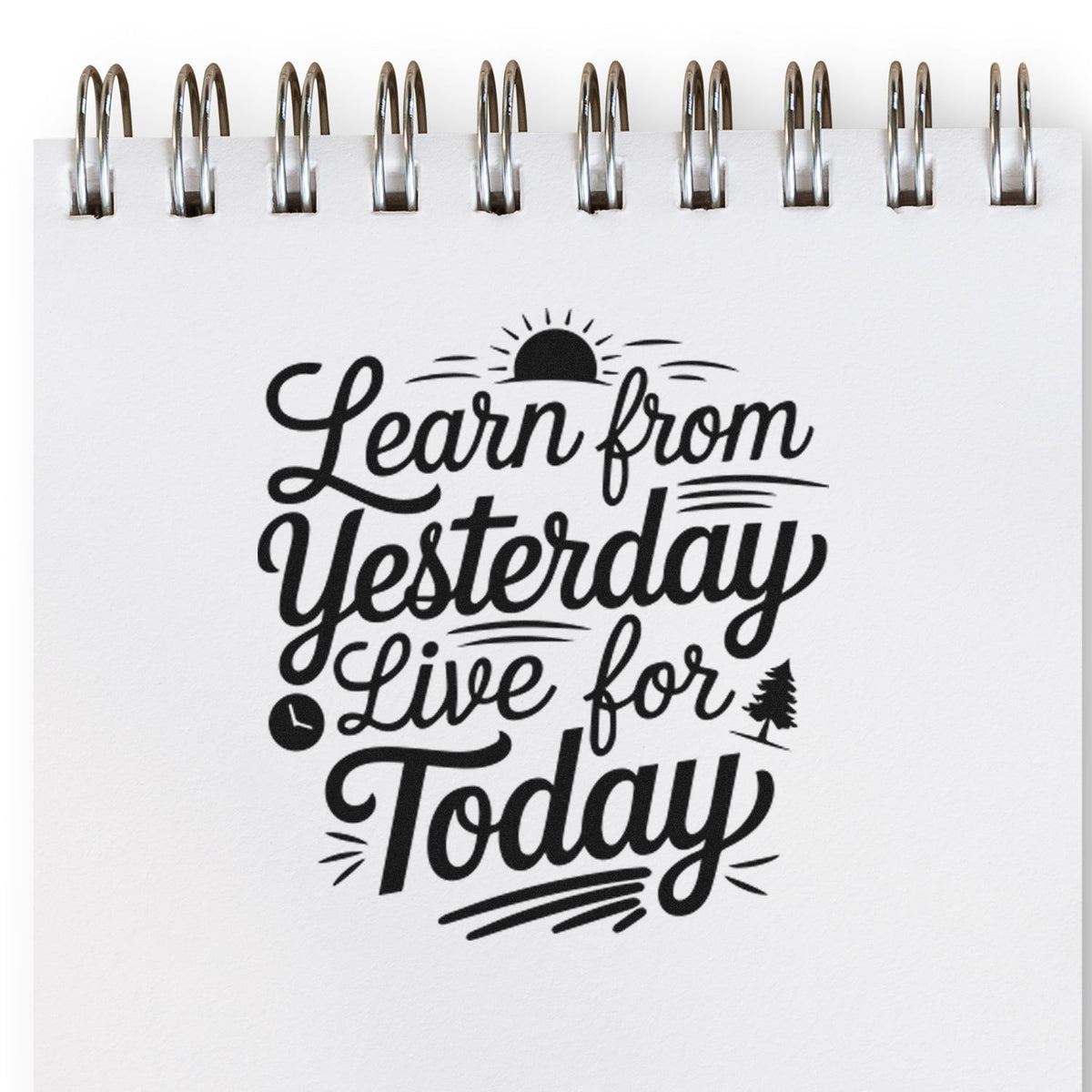 Black stamp-style seal on white spiral notebook cover reading Learn from Yesterday, Live for Today.