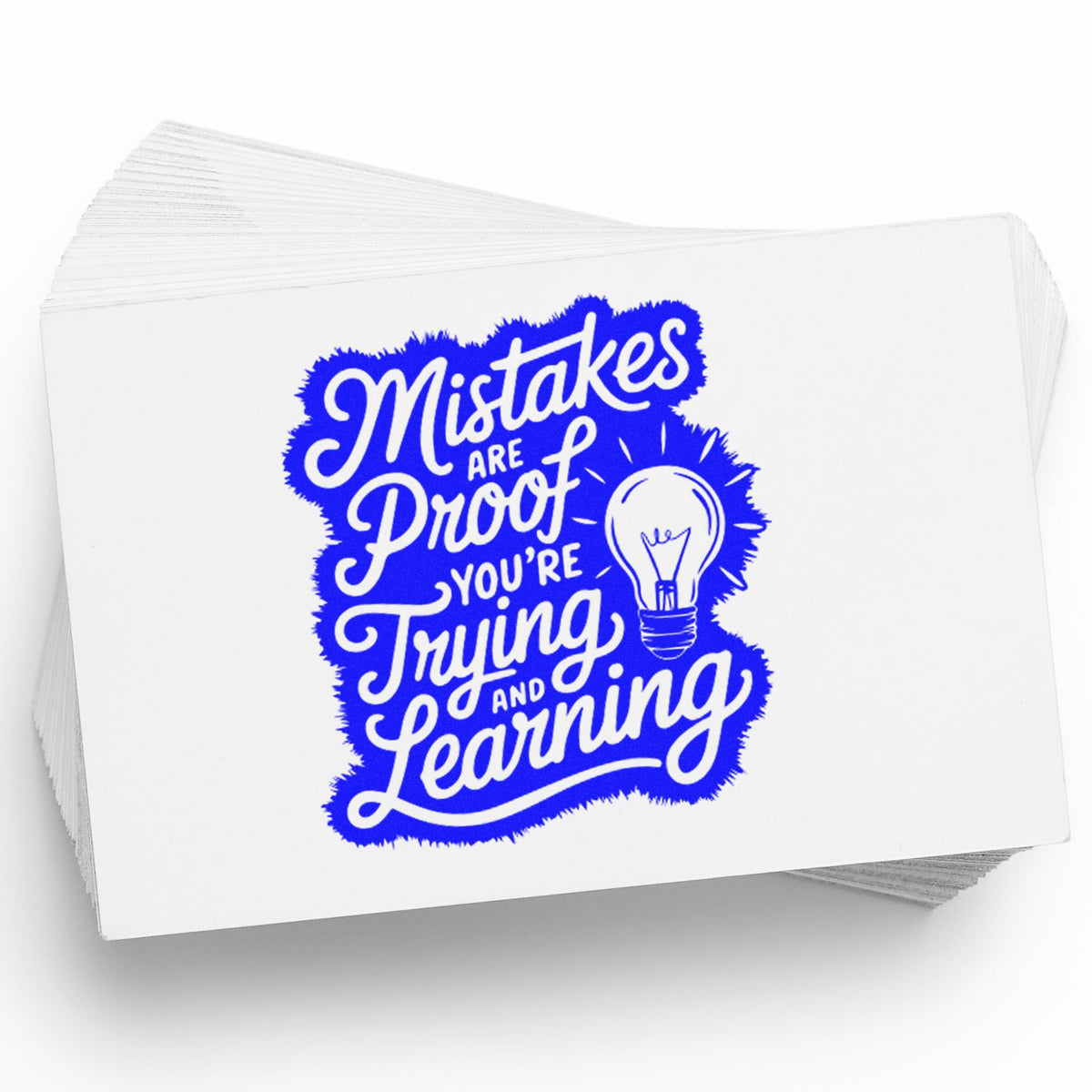 Blue motivational stamp and seal on white card stack, reading Mistakes are proof you're trying and learning with lightbulb.