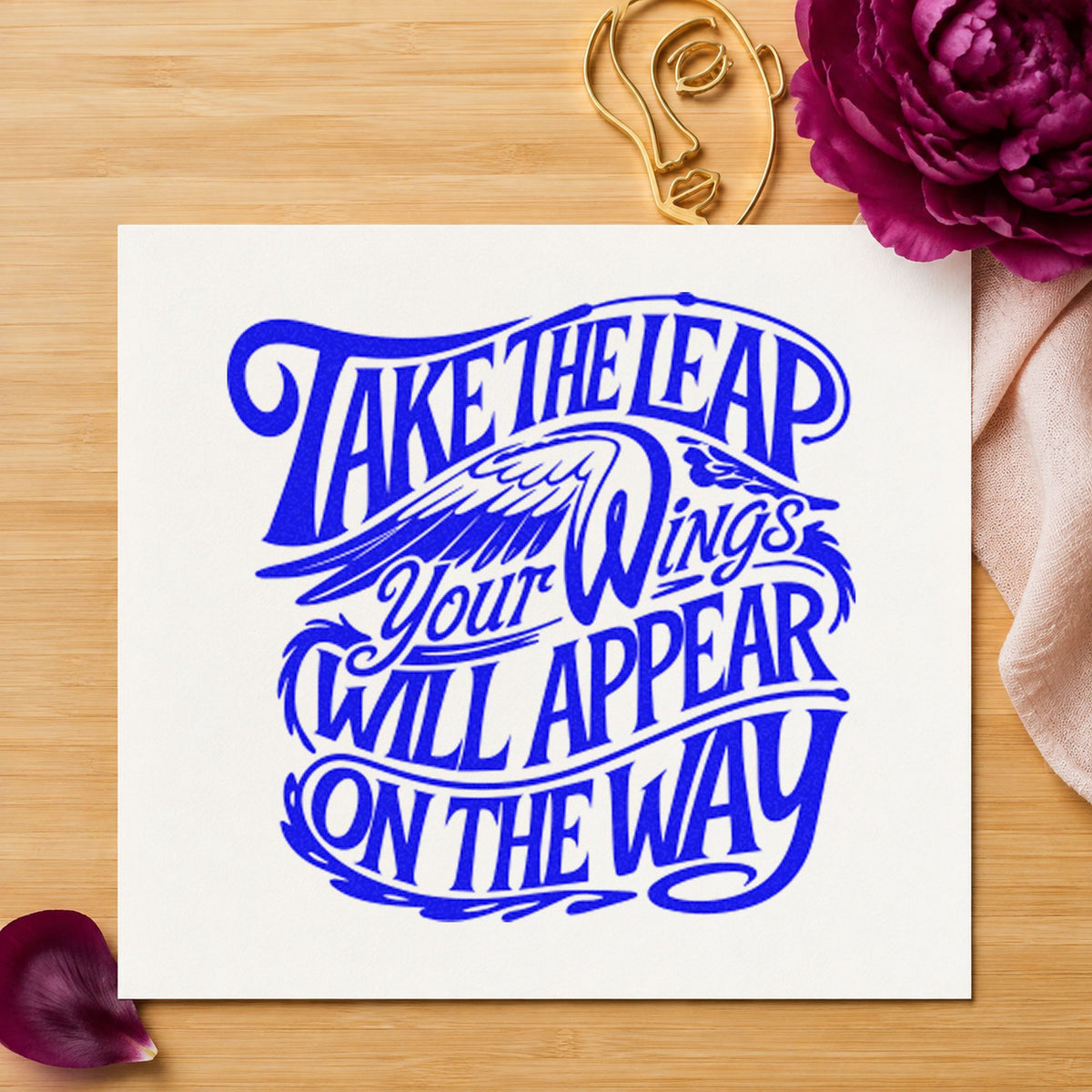 Take Leap Wings Appear craft stamp imprinted in blue ink on paper, a design suited to framed studio door.