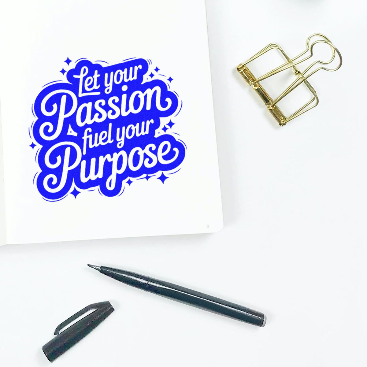 Blue Let your Passion fuel your Purpose stamp on white paper, with gold binder clip and black pen; seal product display.