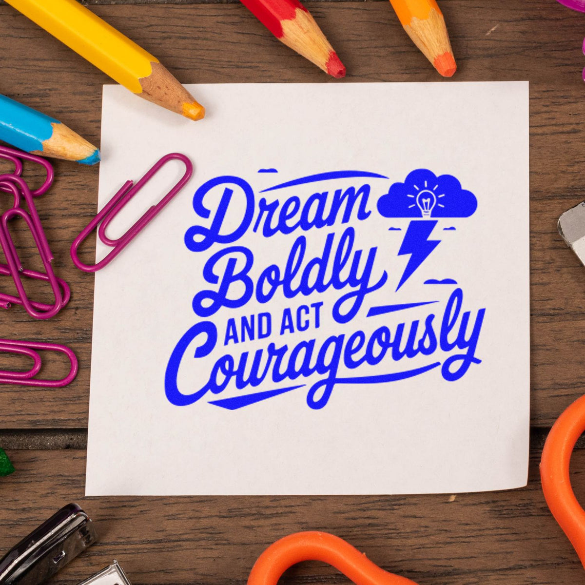 Blue custom stamp and seal on white card reading Dream Boldly and Act Courageously, with cloud-bulb and lightning icon.