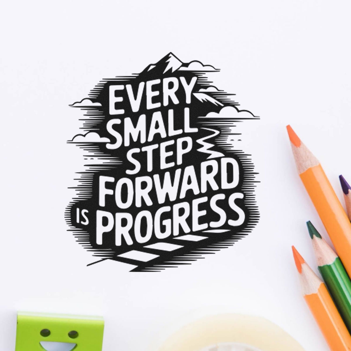 Black stamp seal with mountain graphic and quote Every small step forward is progress, beside orange and green pencils.