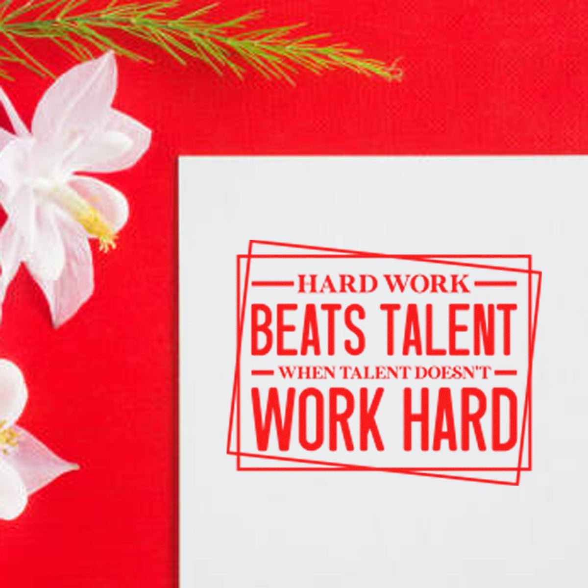 Red stamp and seal with motivational quote, framed in red, on a bright red background with white flowers.