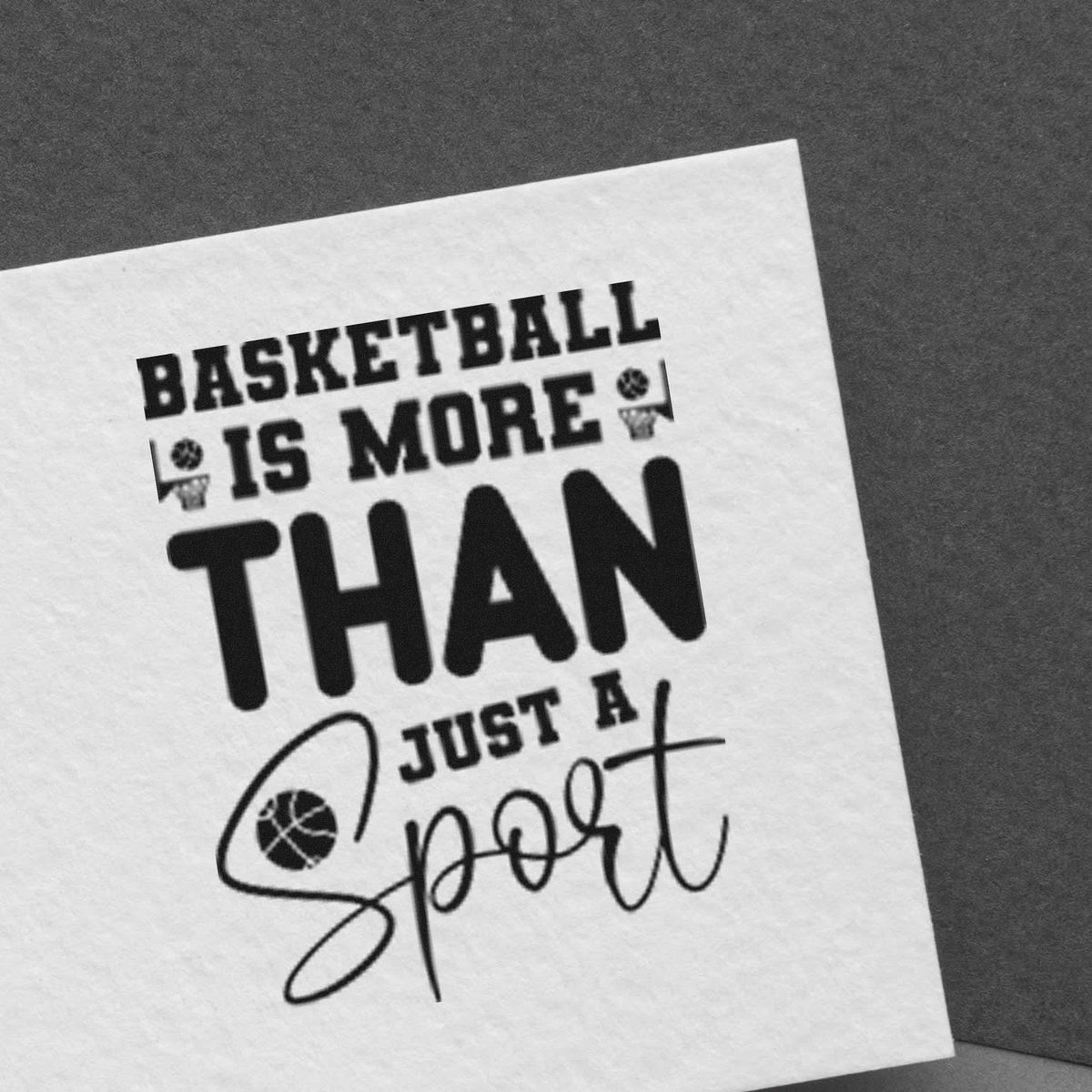Black stamp and seal design on white paper with basketball quote, bold text, and basketball icons on dark gray background.