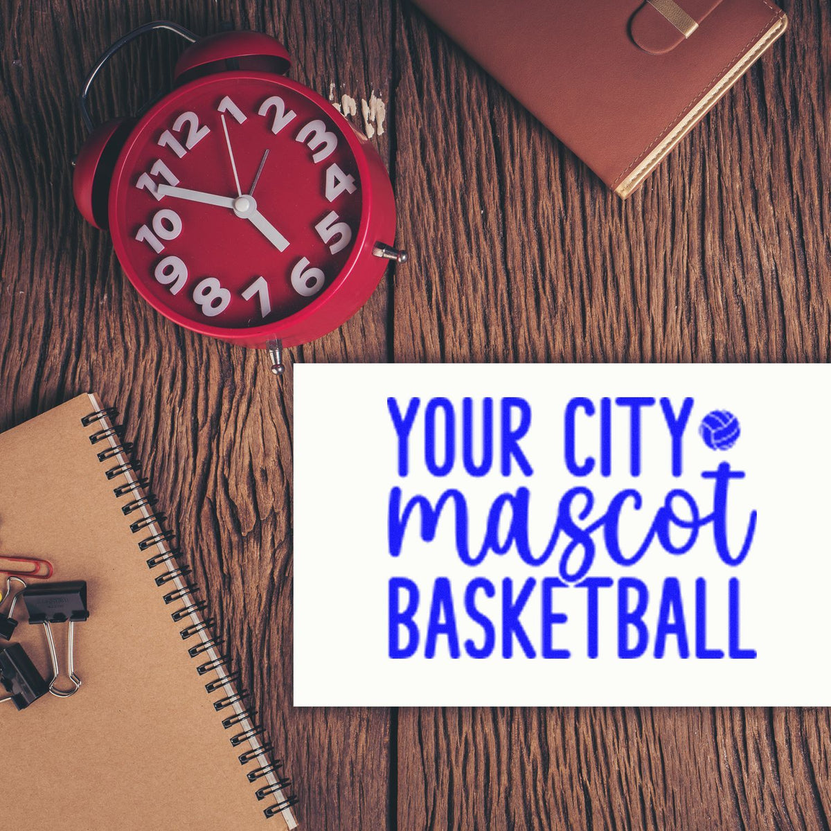 Red clock stamp and blue basketball mascot seal on rustic wood desk with notebook and tan wallet.