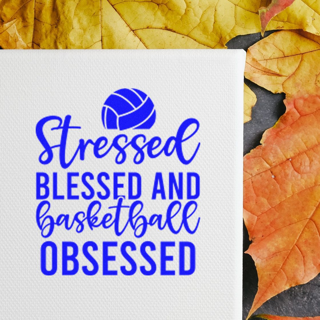 Blue basketball stamp seal with Stressed Blessed and Basketball Obsessed on white textured paper, framed by autumn leaves.