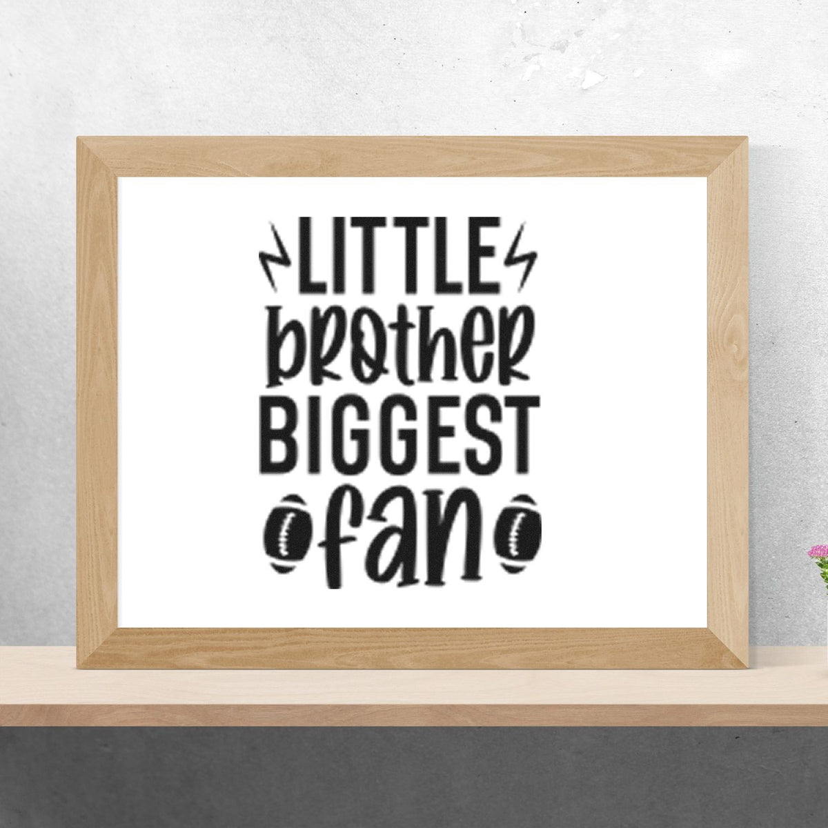 Black stamp design reading Little brother biggest fan with lightning bolts, footballs, and a light wood frame.
