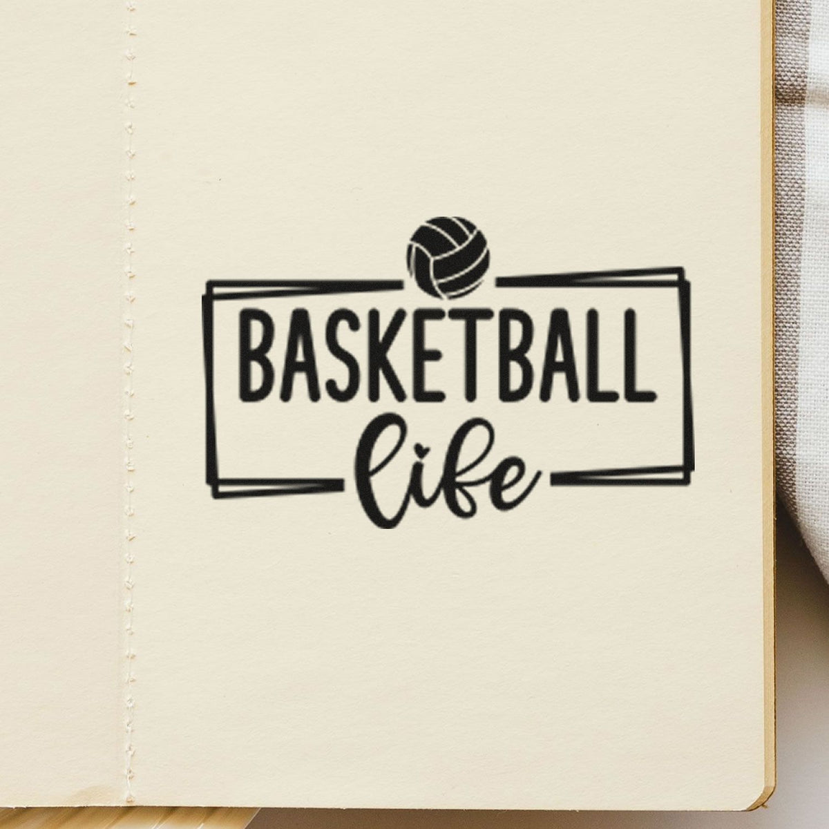 Black Basketball Life stamp seal with ball icon on cream paper background.