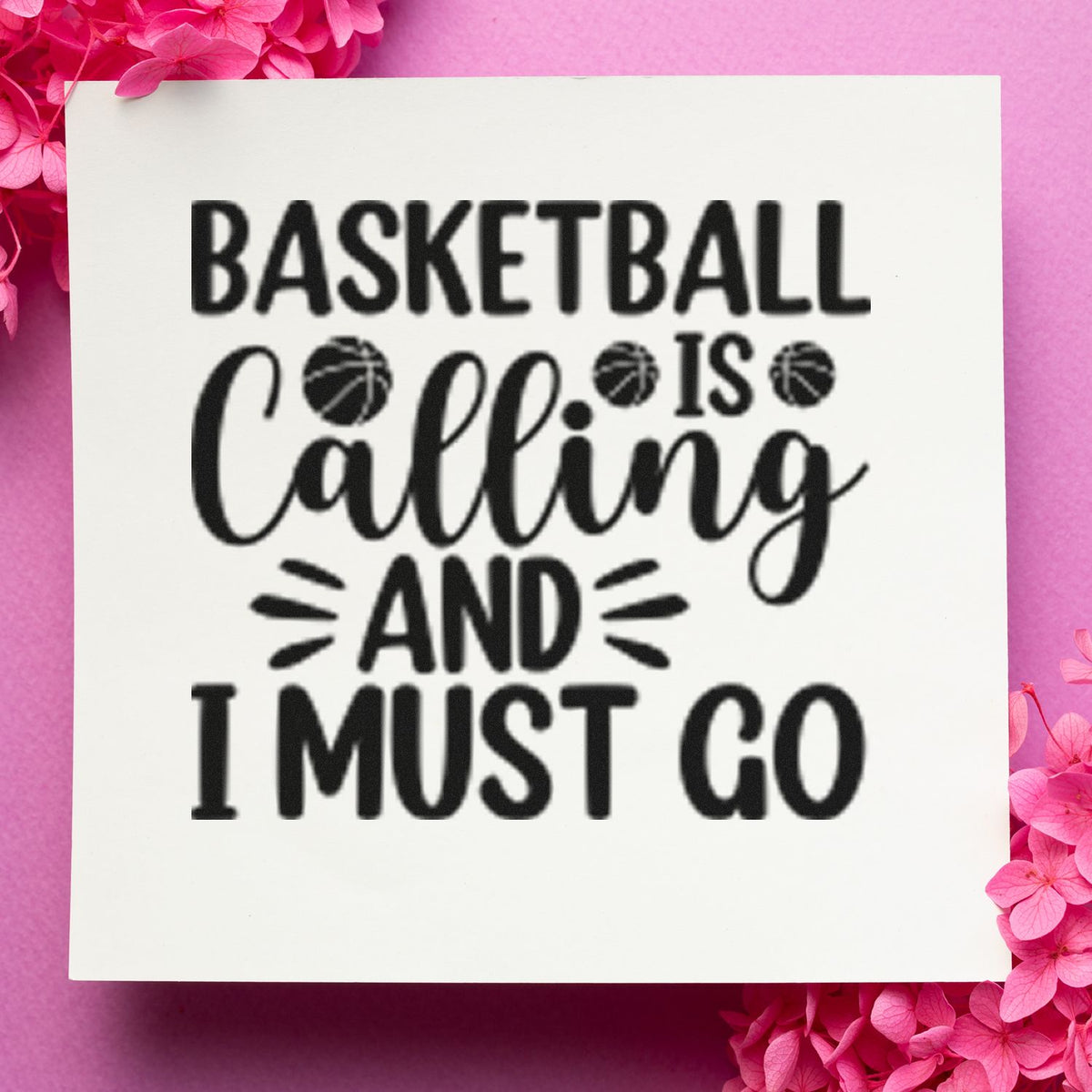 Black basketball quote stamp and seal on a white square, with basketball icons, on a pink floral background.