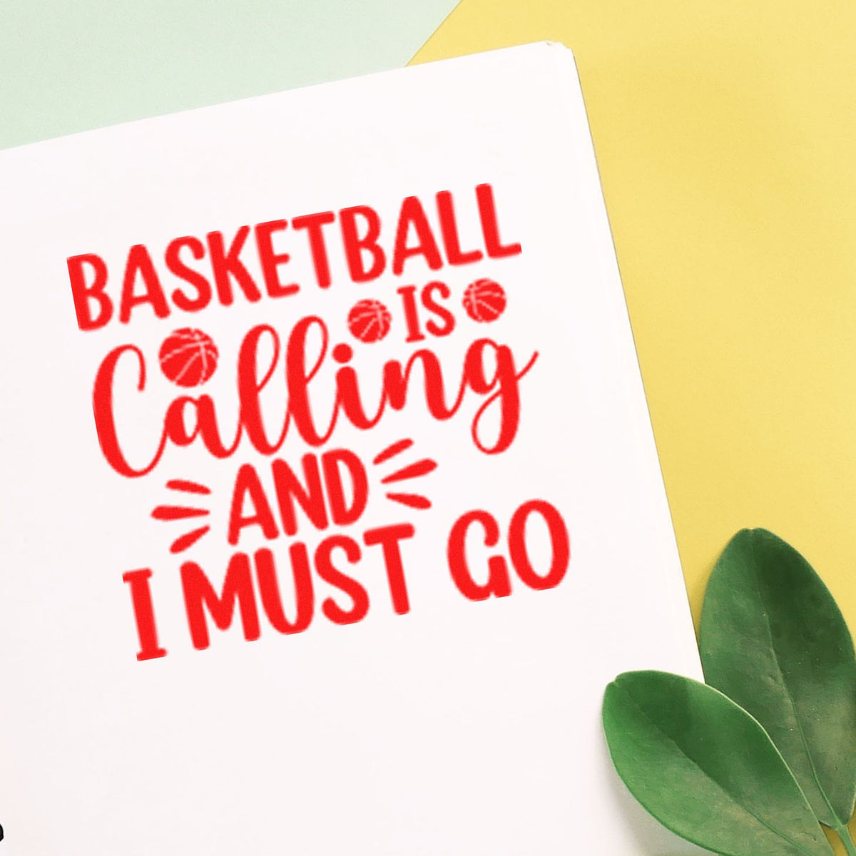 Red basketball-themed stamp seal on white paper, reading Basketball is calling and I must go, with yellow background and green leaves.