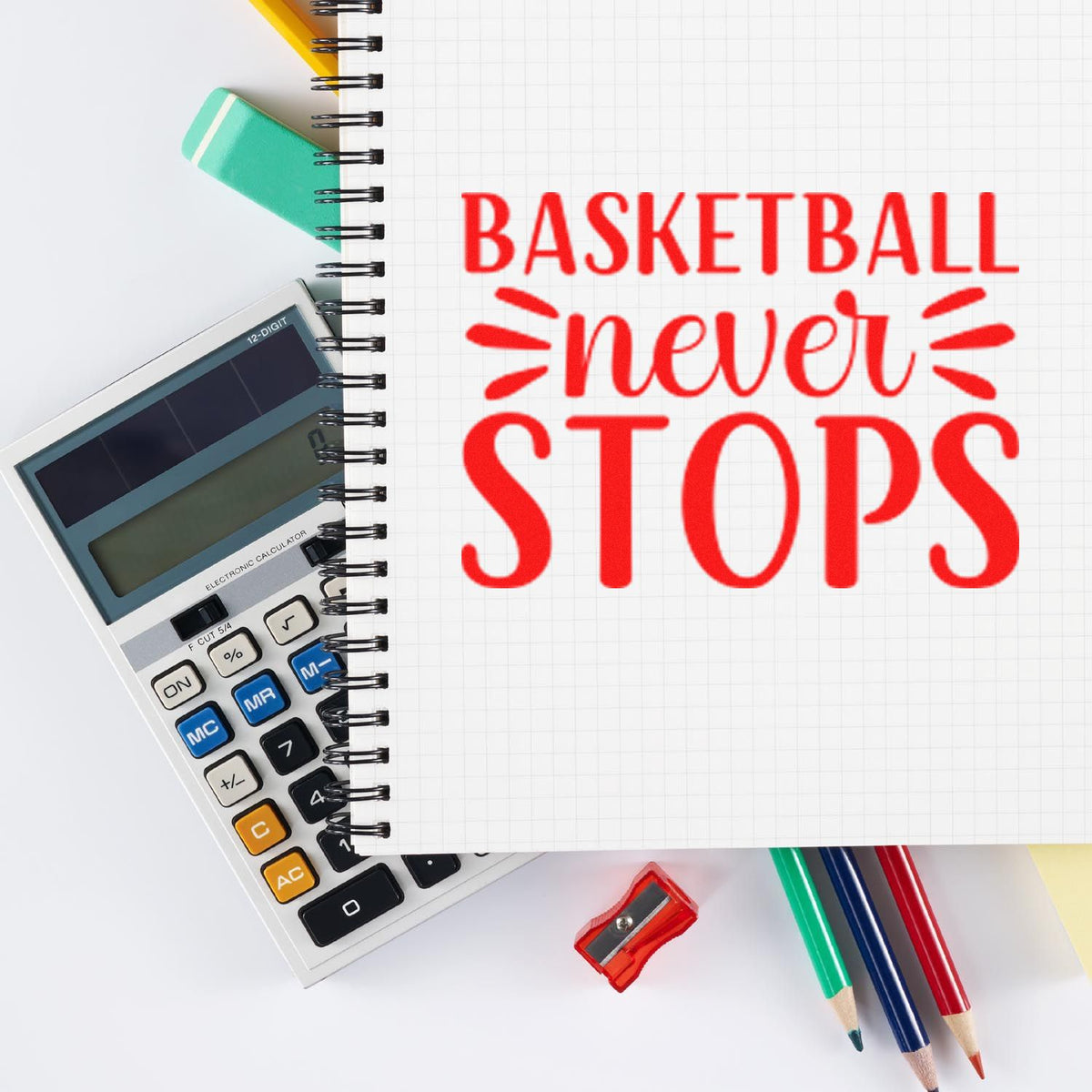 Red basketball never stops stamp on graph notebook with calculator, pencils, eraser, and sharpener.