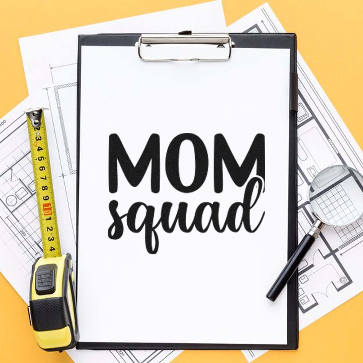 Custom stamp and seal design reading MOM squad on clipboard, with measuring tape, magnifier, and blueprints on yellow background.