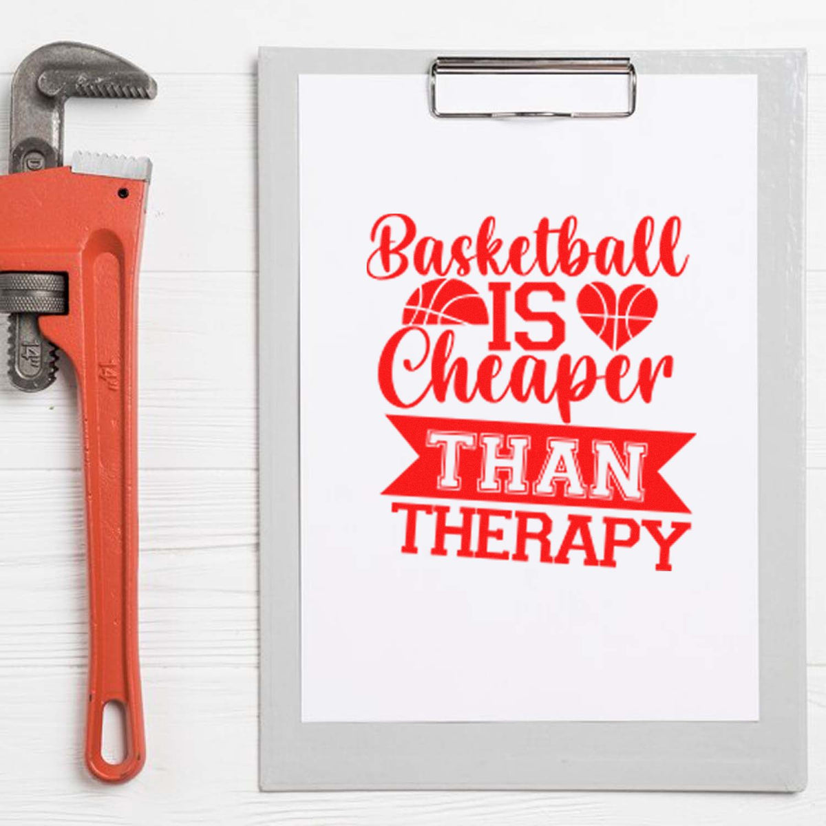 Red basketball-themed stamp design on clipboard reading Basketball is cheaper than therapy, beside an orange pipe wrench.