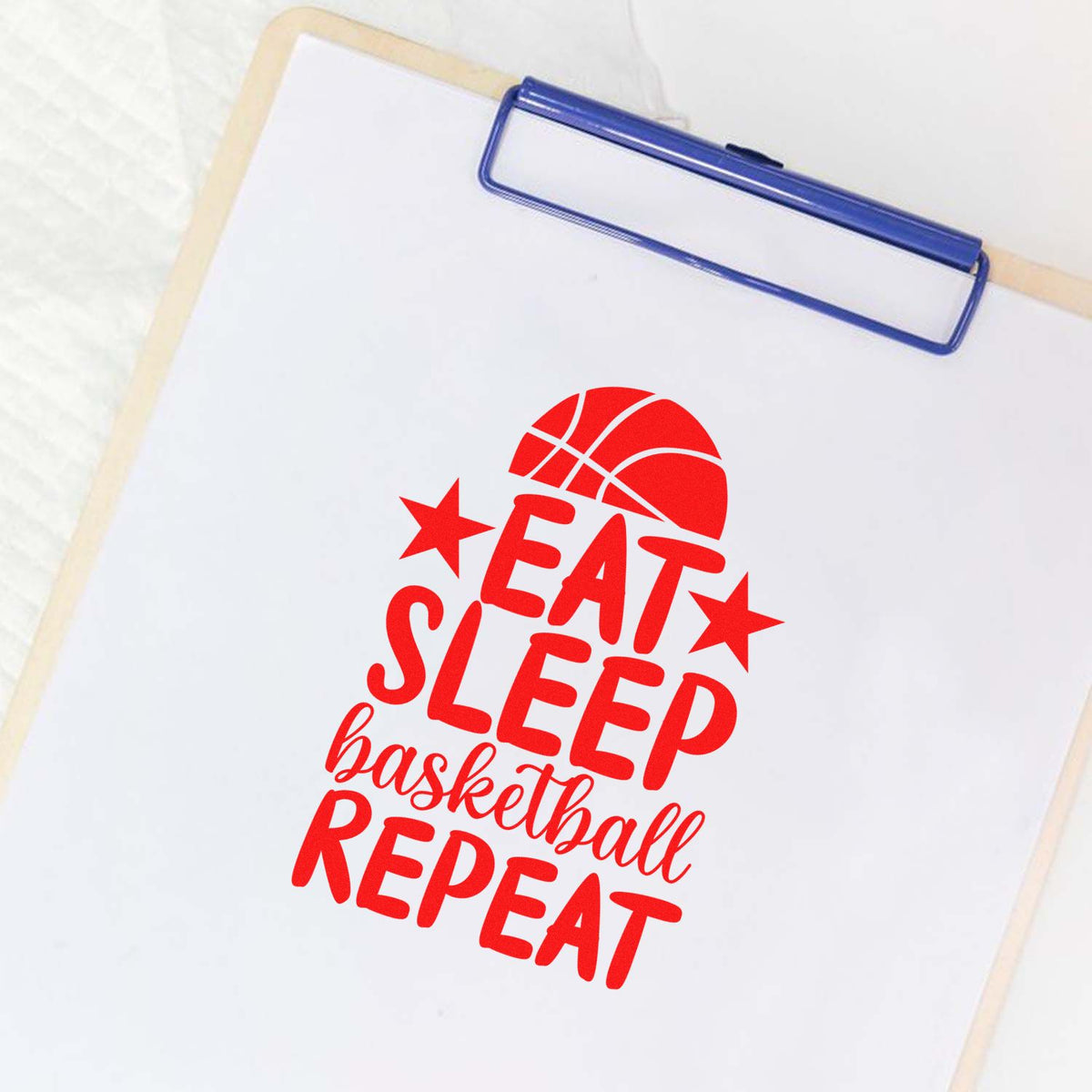 Blue clipboard with a red basketball stamp and seal design reading Eat Sleep basketball Repeat.