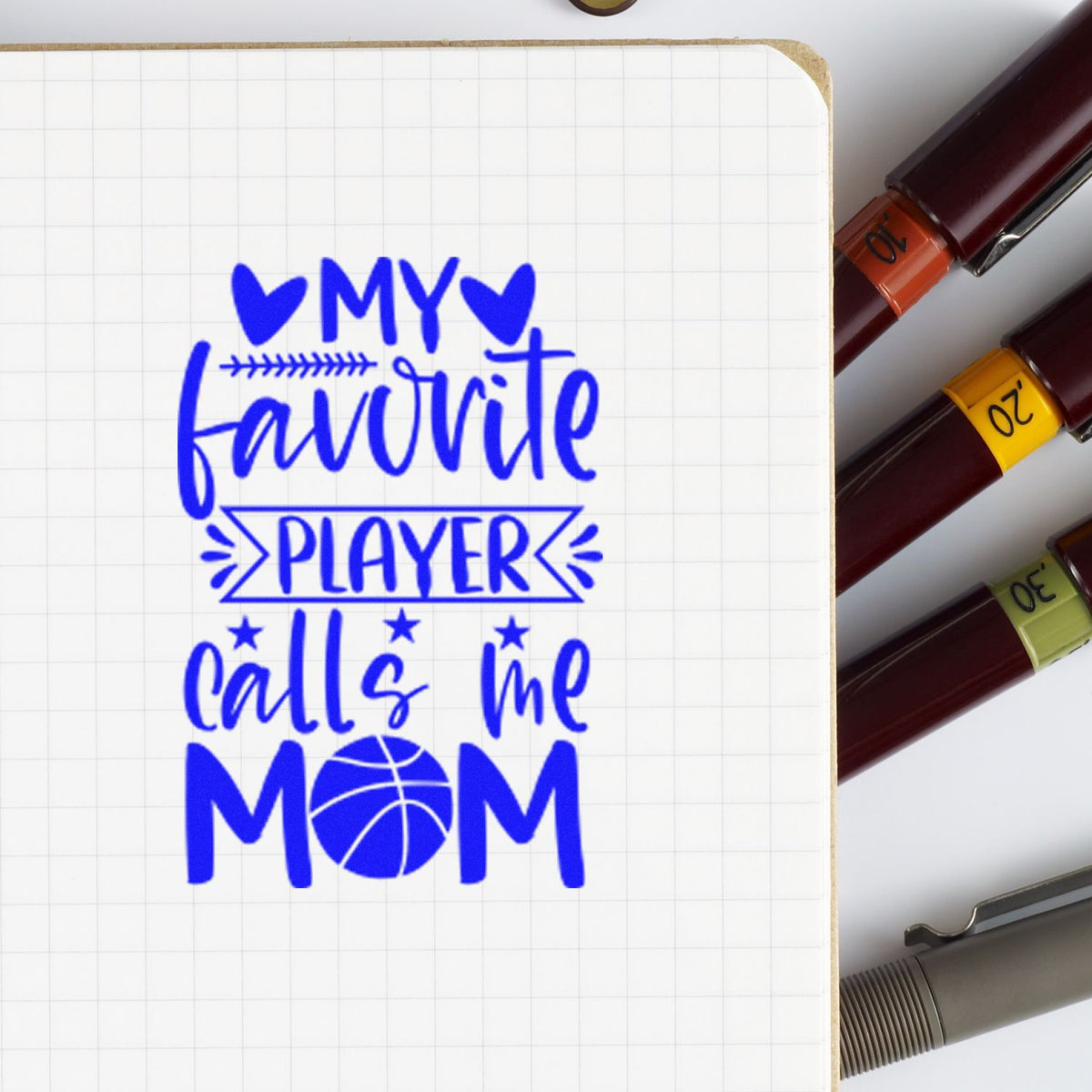 Blue My favorite player calls me mom stamp on grid paper beside maroon seal stamps with orange, yellow, and green labels.
