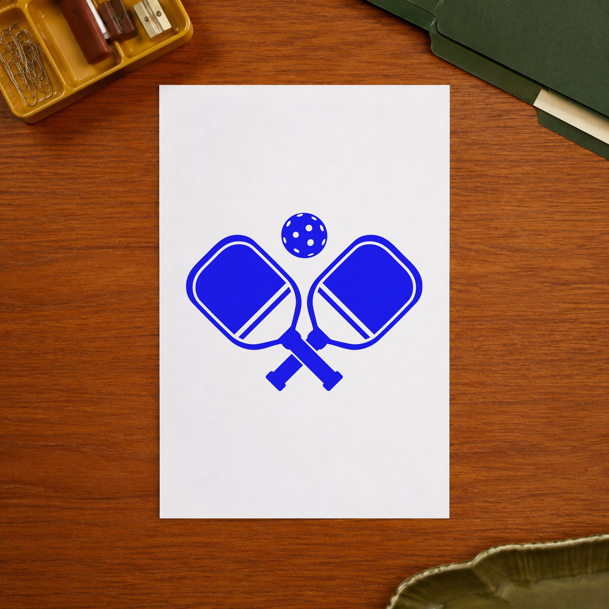Crossed Pickleball Paddles Ball craft stamp in blue ink on cardstock, an easy option for bag panel printing.