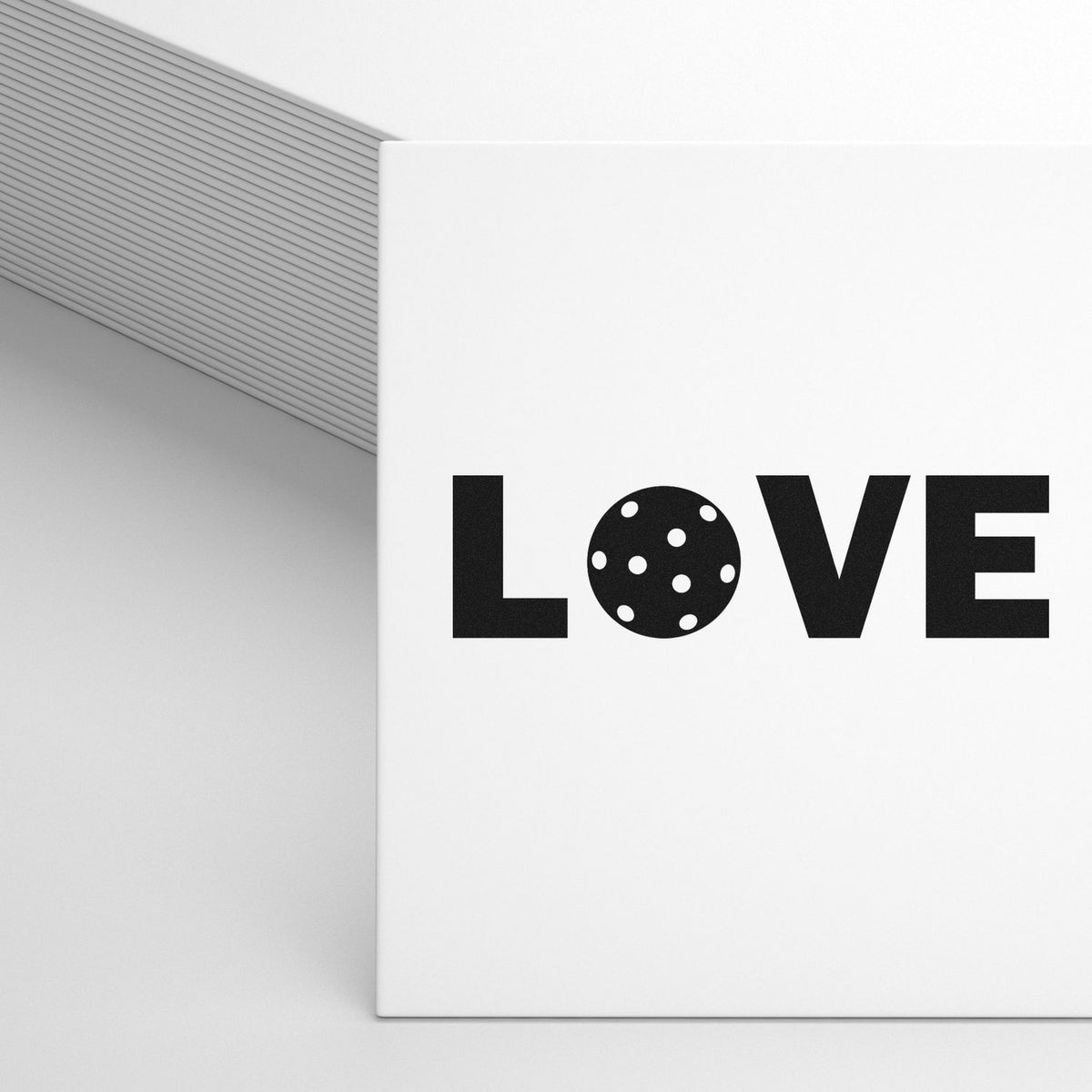 White stamp and seal packaging featuring bold black LOVE, a dotted circular seal O, and a gray striped backdrop.