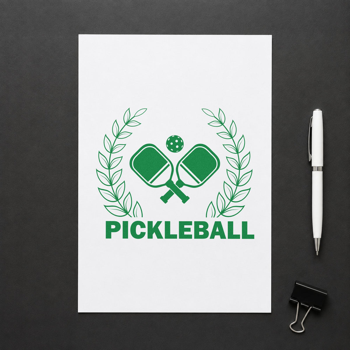 Pickleball Laurel Paddle Badge craft stamp imprint in green ink on a handmade project, one idea being event info cards.