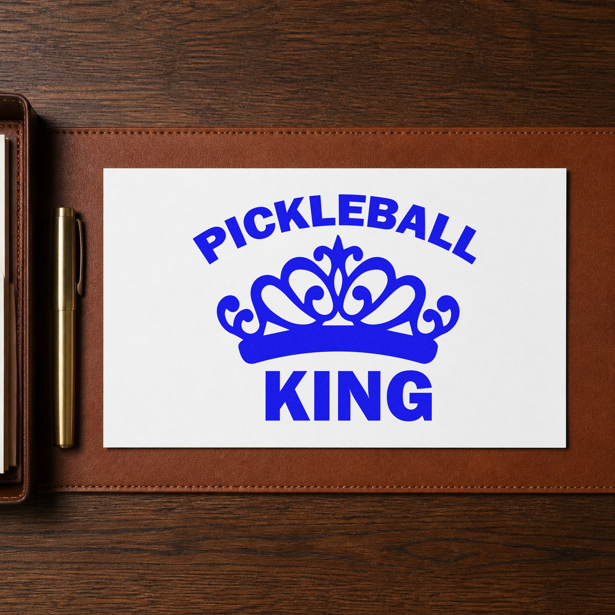 Pickleball King Crown Graphic craft stamp imprinted in blue ink on paper, a design suited to framed garage shelf.