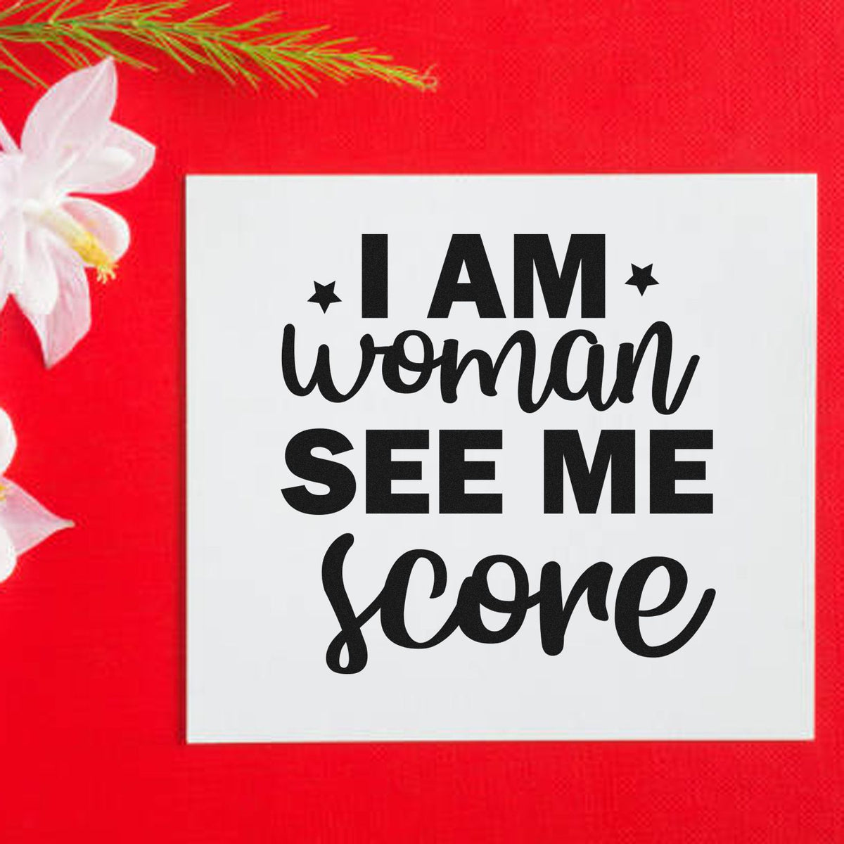 White square stamp and seal with black I AM woman SEE ME soar text on a bright red background with white flowers.