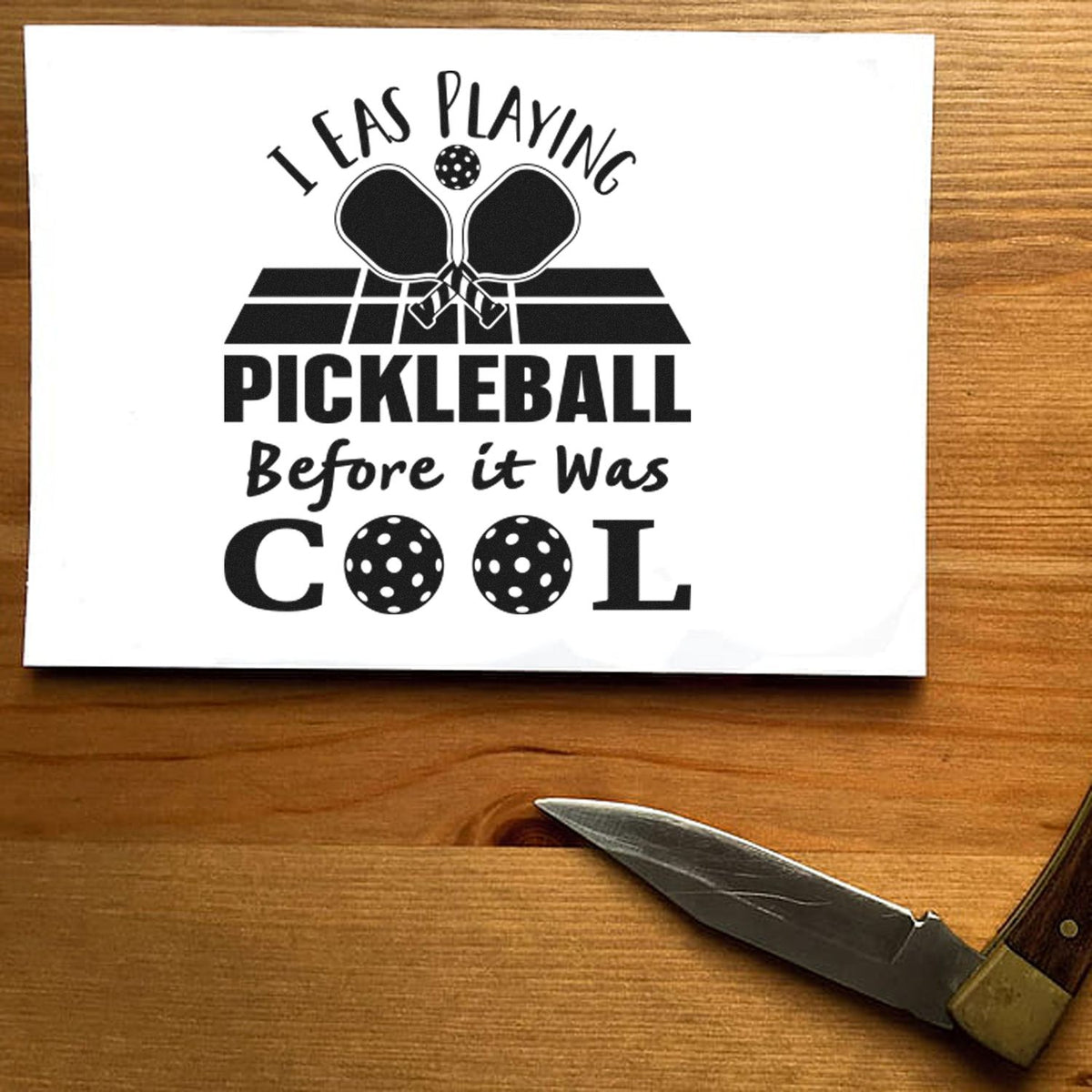 Black pickleball stamp and seal design on white paper with paddles, ball, and bold text I was playing pickleball before it was cool.