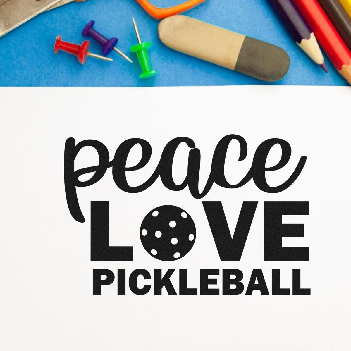 Custom stamp and seal for Peace Love Pickleball in black, with colorful pushpins, pencils, and a blue background.