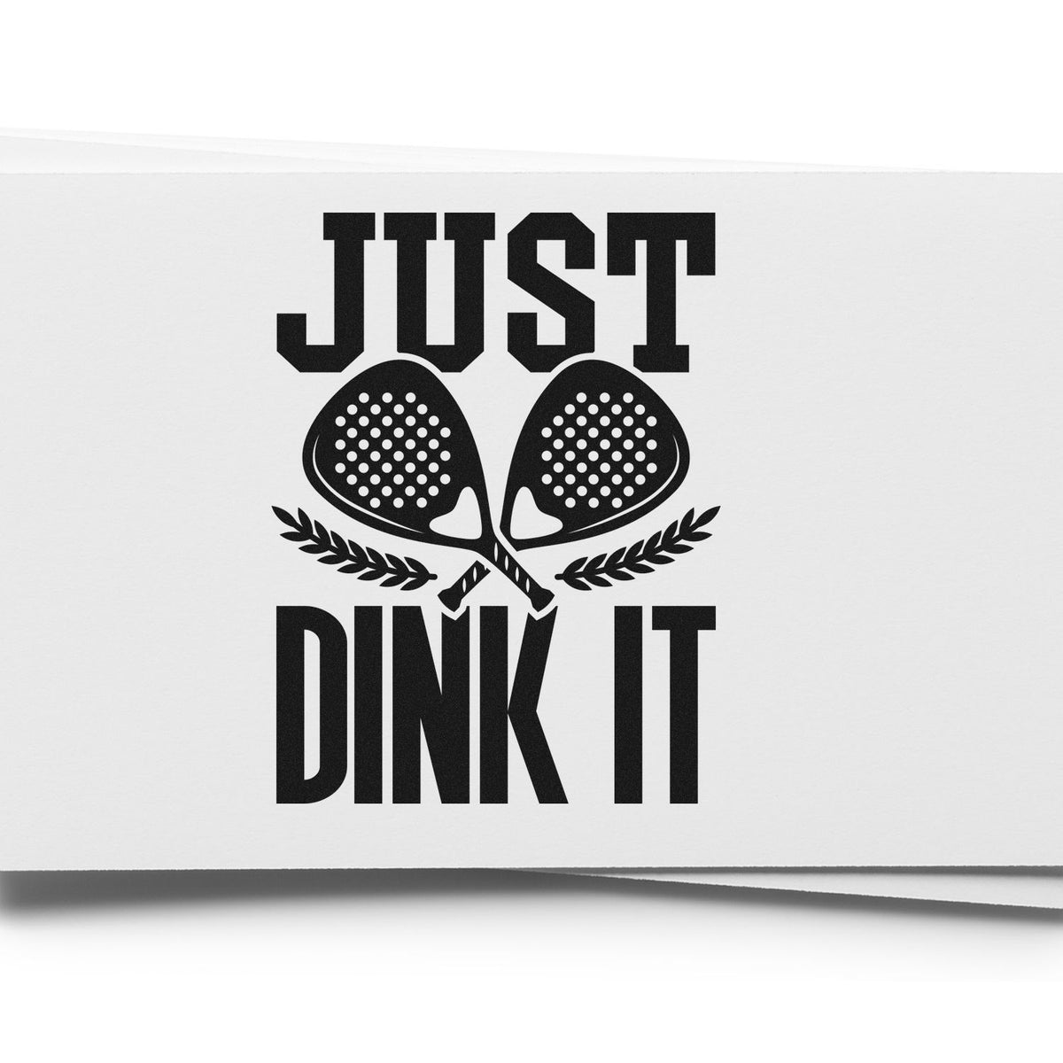 Black stamp/seal design with JUST DINK IT, crossed pickleball paddles, and laurel on a white background.