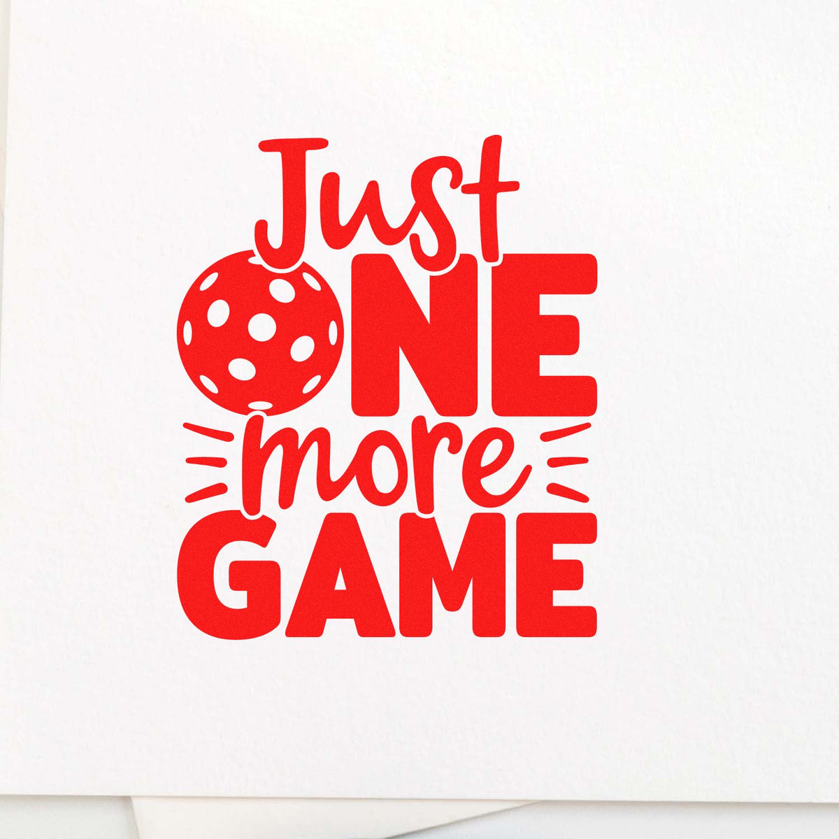 Red Just One More Game stamp design with bold lettering, polka-dot ball, and accents on a white background.