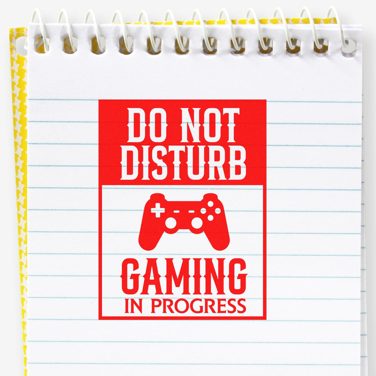Red seal-style stamp reading Do Not Disturb Gaming in Progress with a controller icon on a white spiral notebook.