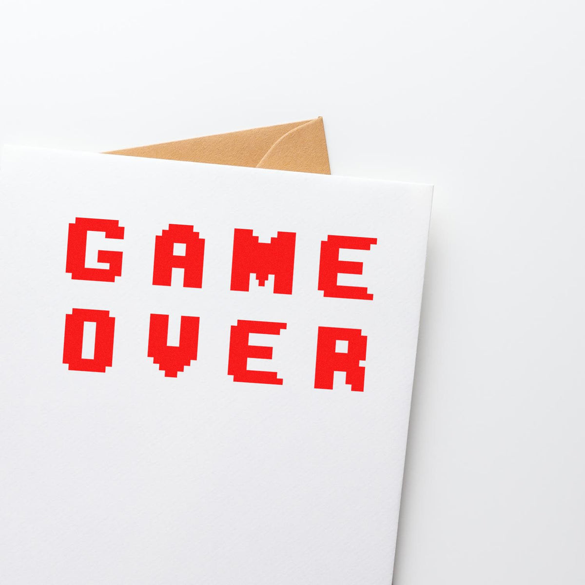Red pixel-style GAME OVER stamp on a white envelope with tan seal flap