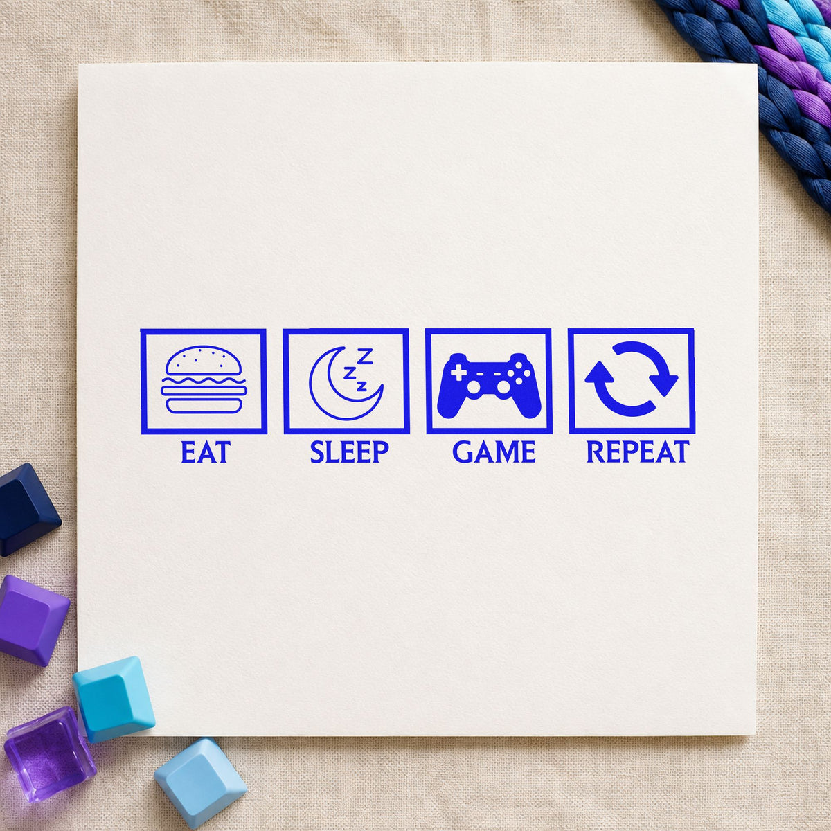 Eat Sleep Game Repeat craft stamp imprinted in blue ink on paper, a design suited to framed hall desk.