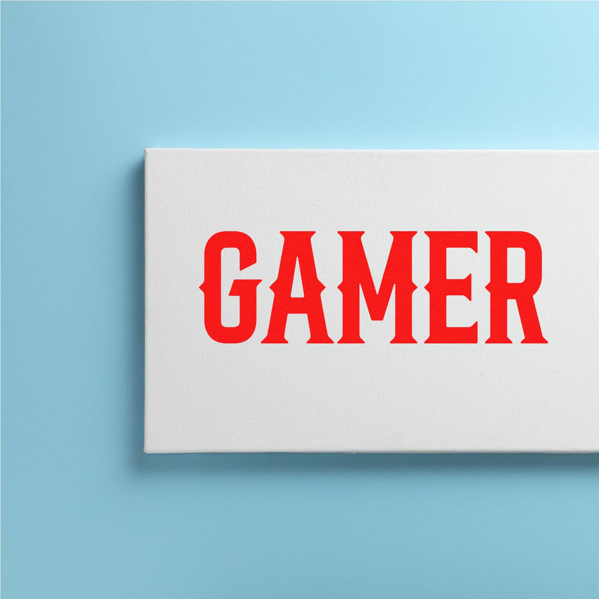 White stamp and seal block with bold red GAMER text on a light blue background.