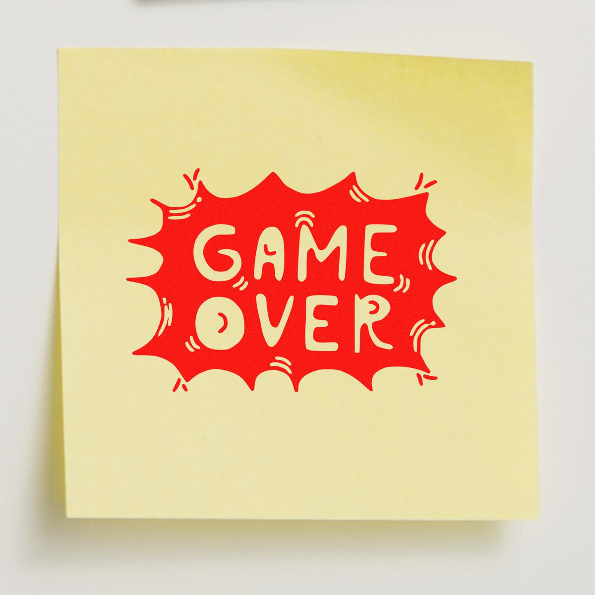 Red GAME OVER stamp seal on pale yellow paper, comic-style burst graphic