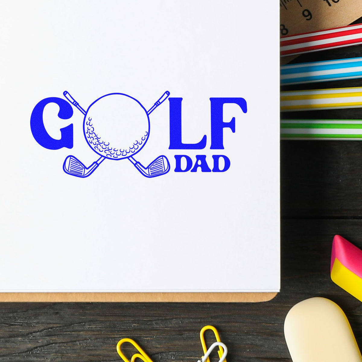 Blue GOLF DAD stamp with golf ball and clubs logo on white paper, beside colorful seal swatches.