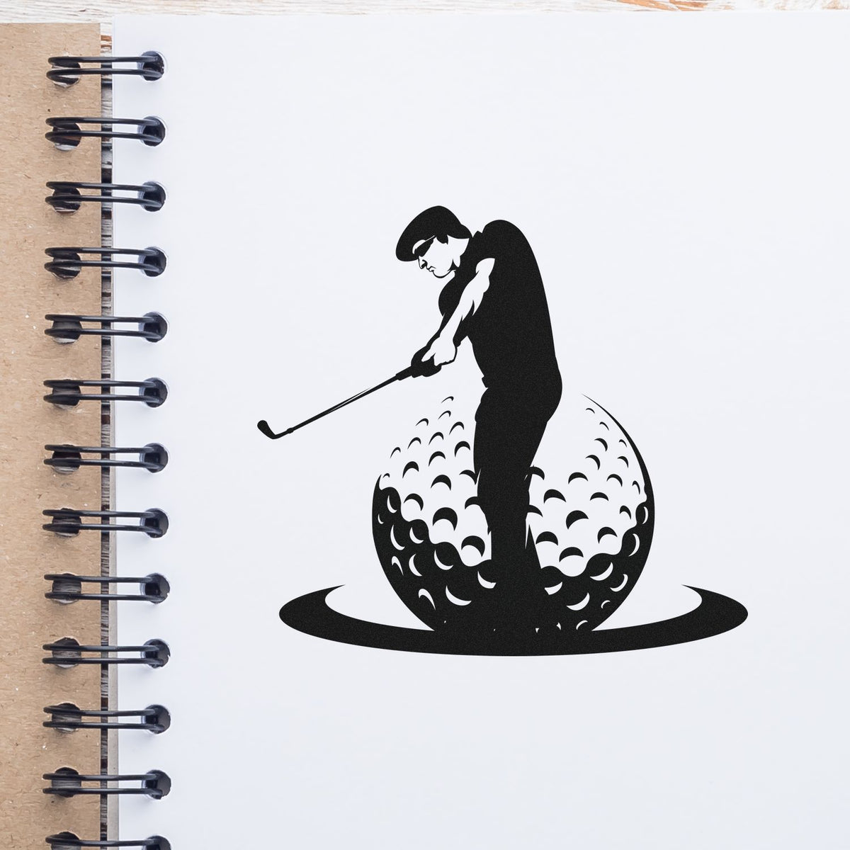 Black golf stamp seal design on white notebook page, showing a golfer putting on a textured golf ball.
