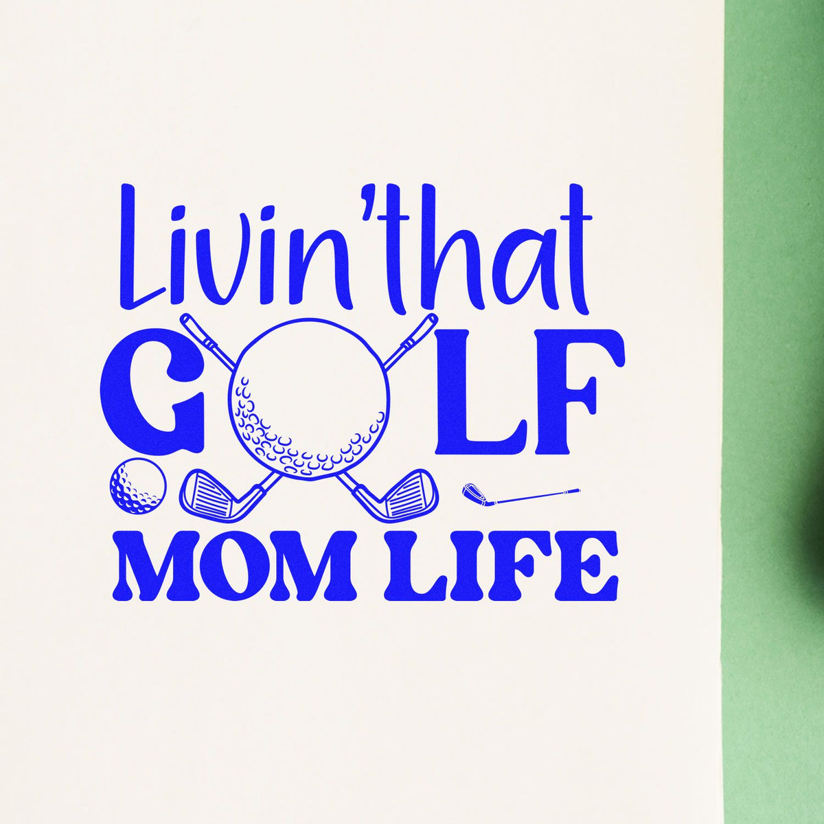 Blue golf stamp and seal design with club-and-ball graphic and bold Livin That Golf Mom Life text on cream background.