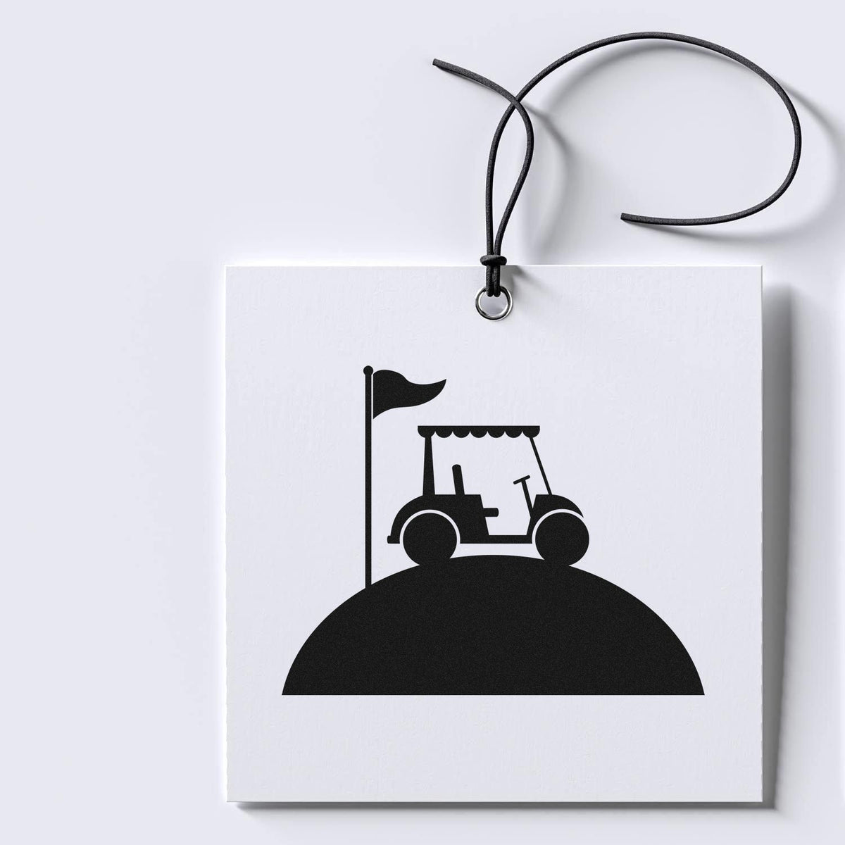 Black stamp and seal tag with a golf cart and flag icon, hanging on a black cord against a white background.