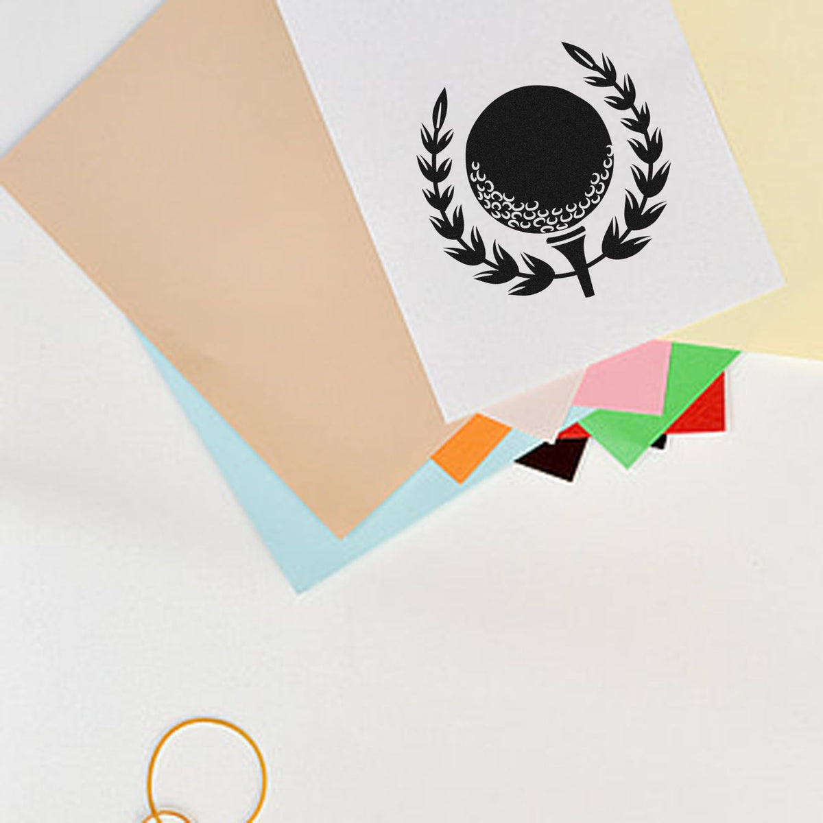 Black laurel seal stamp on white paper, with pastel paper swatches and color sample cards.