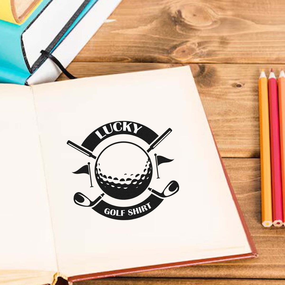 Black Lucky Golf Shirt stamp seal with golf ball, clubs and flags on an open notebook beside colored pencils.
