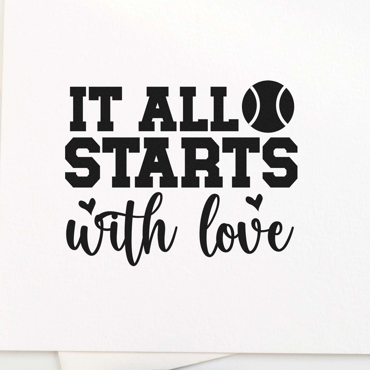 Black stamp-style seal reading It all starts with love, with a tennis ball icon and small hearts on a white background.