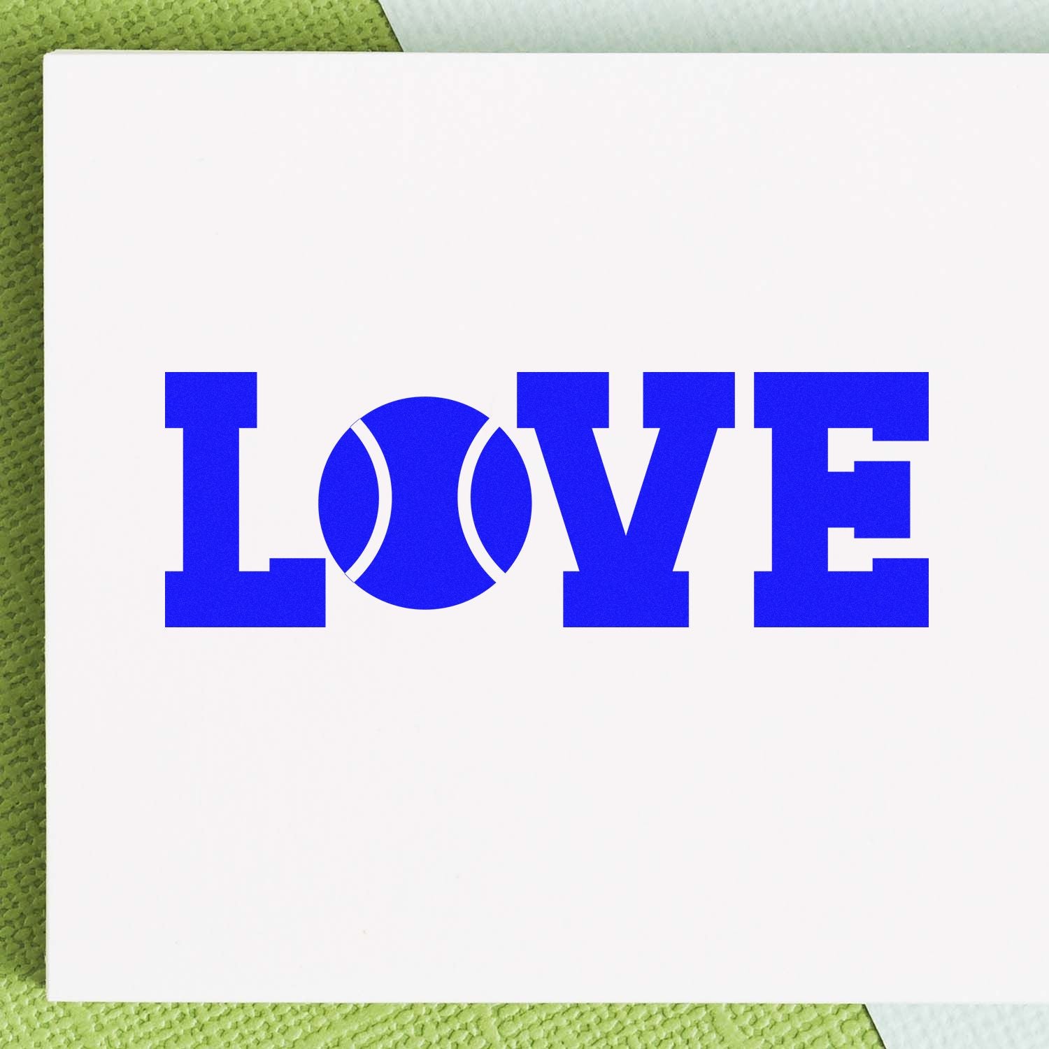 Blue LOVE tennis-themed stamp and seal on white card, with a tennis ball as the O, set against a green background.