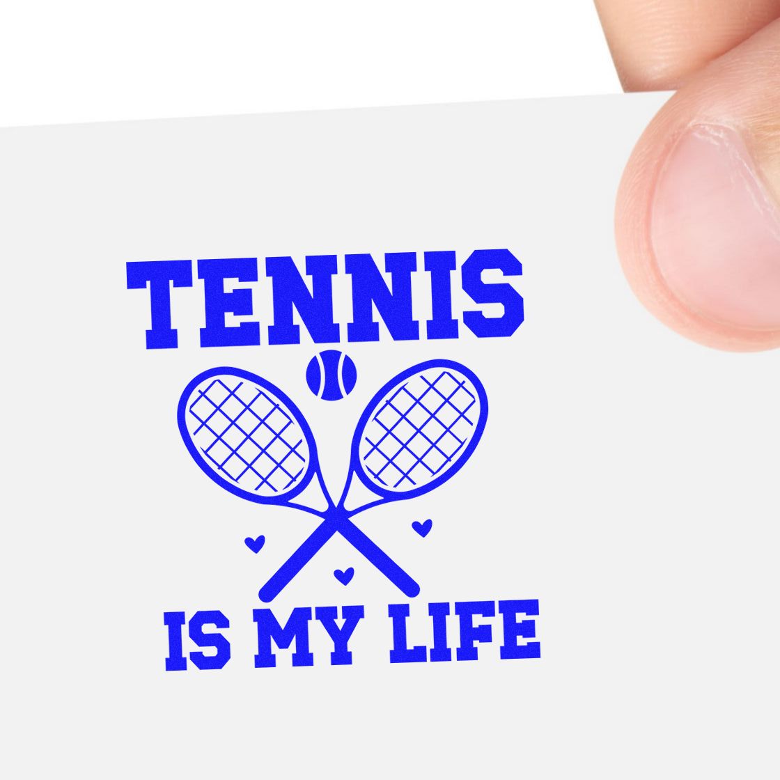 Blue tennis stamp seal with crossed rackets, ball and hearts on a white card held by fingers.