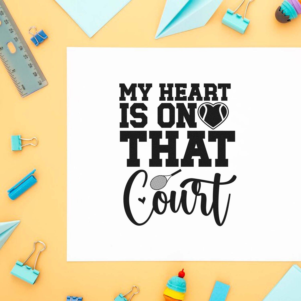 Black tennis stamp and seal reading My Heart Is On That Court on white paper, with pastel blue stationery on yellow.