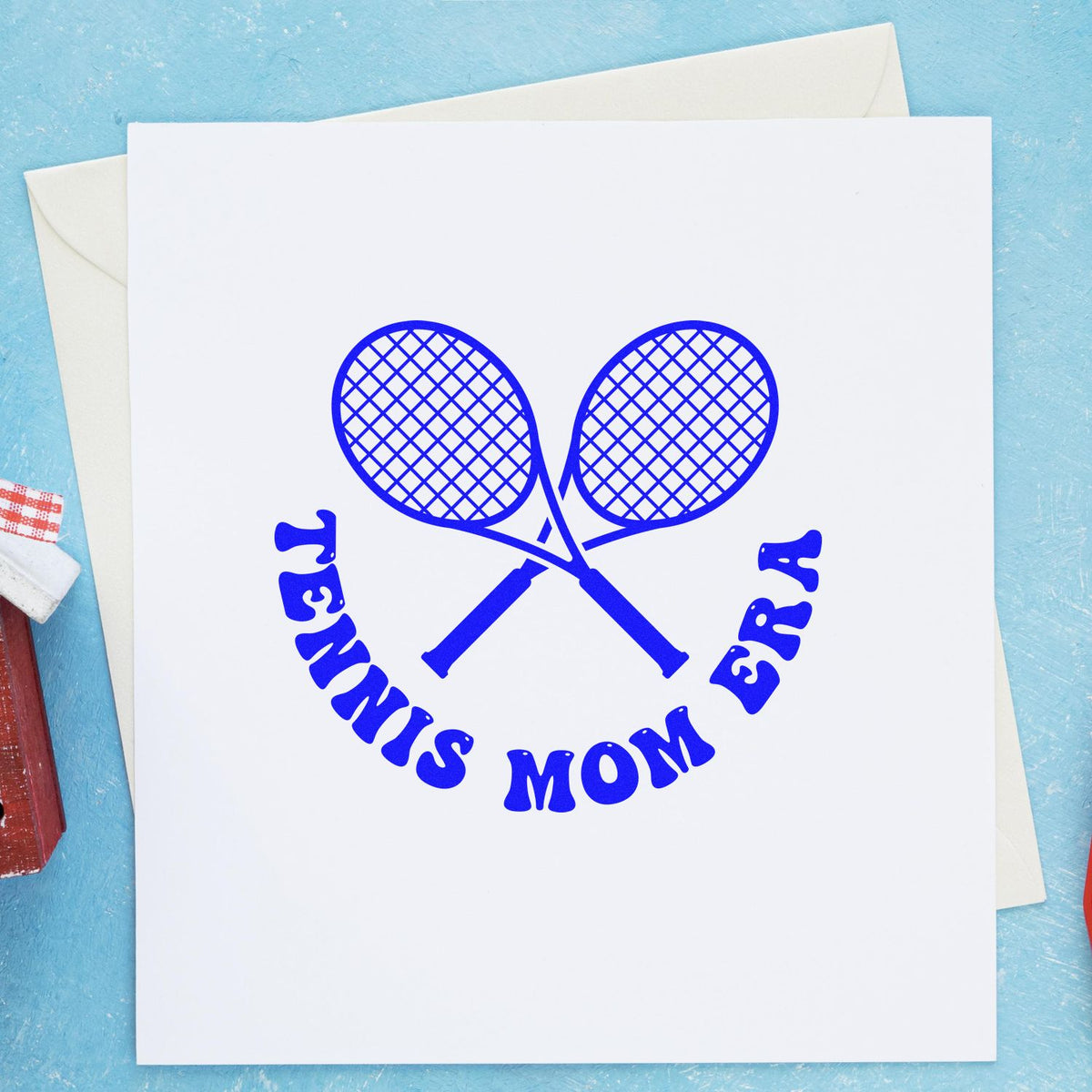 Blue tennis racket stamp and seal design with crossed rackets and Tennis Mom text on a white card.
