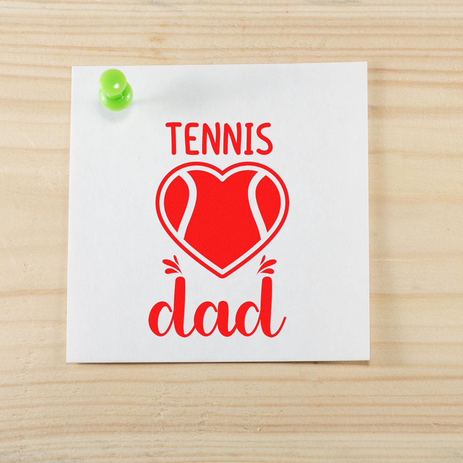 Red tennis dad stamp seal on white card, with heart-shaped tennis ball and green pushpin on wood grain.