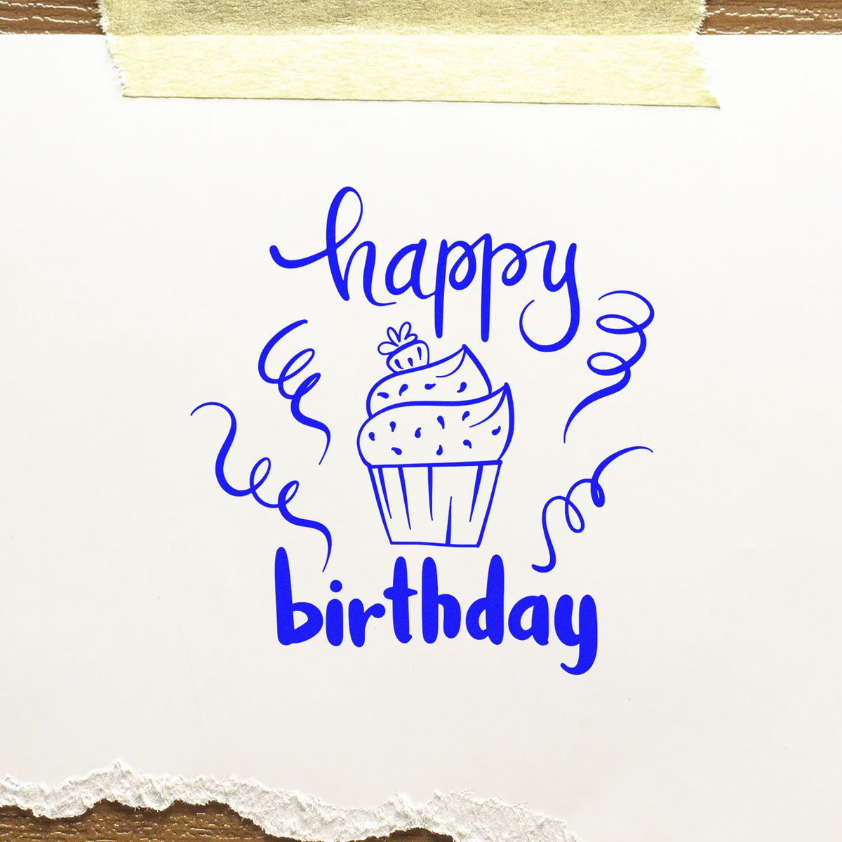 Blue happy birthday stamp seal with cupcake, confetti, and handwritten lettering on white paper.