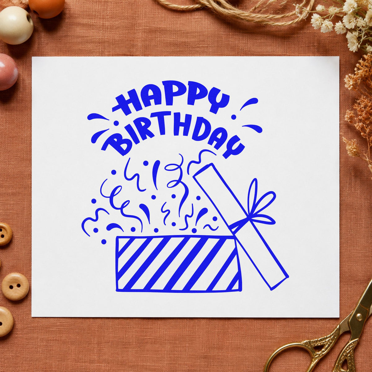 Birthday Open Gift Confetti craft stamp imprinted in blue ink on paper, a design suited to framed wrap corner.